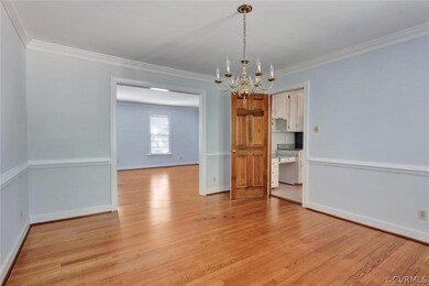 The dining room with crown moulding, chair rail an