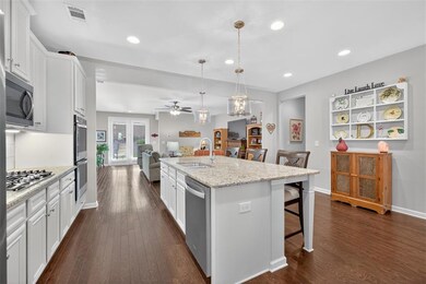 Kitchen featuring a breakfast bar area, white cabinetry, decorative light fixtures, recessed lighting, and dark wood-type flooring