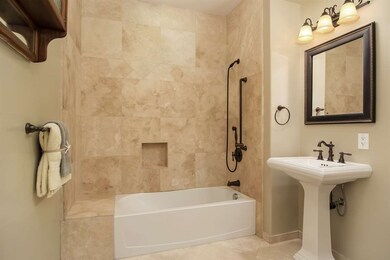 Travertine tile shower/tub enclosure and flooring,