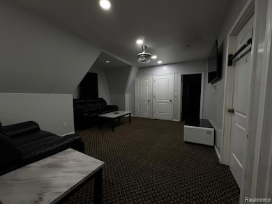 Sitting room with dark carpet, recessed lighting, and vaulted ceiling