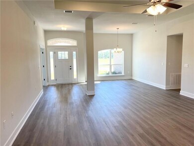 Entrance foyer featuring a ceiling fan, dark wood-type flooring, and a chandelier