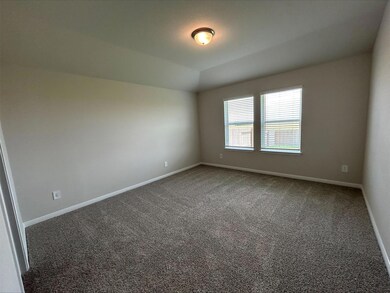 Carpeted spare room featuring baseboards