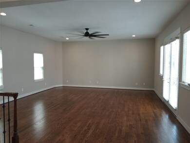 Spacious living room with hardwood floors and many