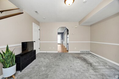 Unfurnished living room with arched walkways and carpet