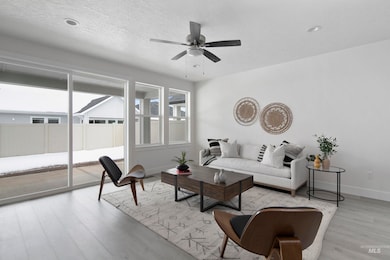 Living area featuring a textured ceiling, light wood finished floors, and a ceiling fan