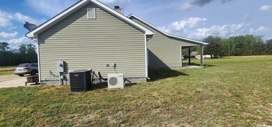 View of side of property featuring a yard, ac unit
