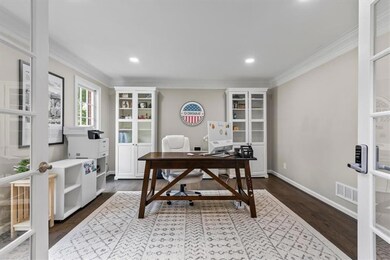 Home office with ornamental molding, dark wood-type flooring, and recessed lighting