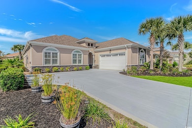 Mediterranean-style home featuring stucco and stone siding, side load insulated garage, and resurfaced driveway