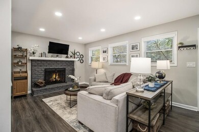 Inviting Fireside Family Room With A Classic Brick Fireplace & Abundant Natural Light