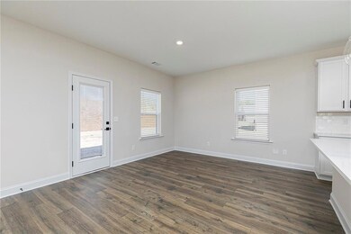 Unfurnished dining area featuring dark wood-type flooring and recessed lighting