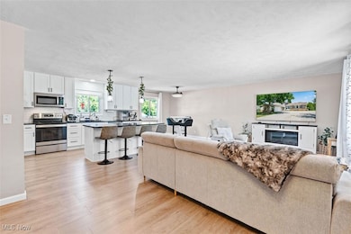 Living area with light wood-style floors and a textured ceiling