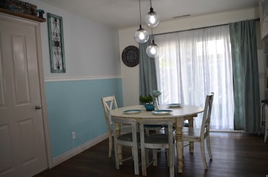 Dining room featuring dark wood-style flooring and baseboards