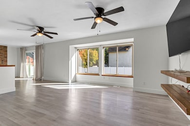 Unfurnished living room with light wood-style floors and a ceiling fan