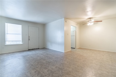 Empty room featuring ceiling fan and baseboards