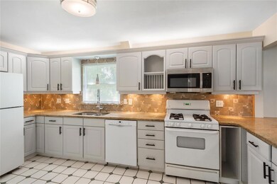 Kitchen updated with white cabinets, granite count
