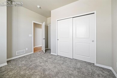 Unfurnished bedroom featuring carpet flooring, baseboards, and a closet