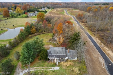 Aerial view of property and surrounding area featuring a nearby body of water and a tree filled landscape
