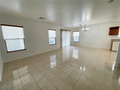 Unfurnished room featuring a chandelier, baseboard