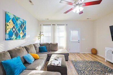 Living room with light wood-style flooring and ceiling fan