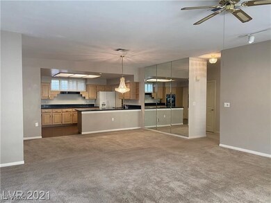 Kitchen featuring carpet flooring, a ceiling fan, white refrigerator with ice dispenser, open floor plan, and dark countertops