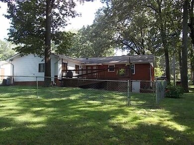 View showing rear of the home, deck and fenced area. Nice level yard.