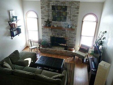 Living Room. Living room features vaulted ceiling, floor to ceiling brick gas fireplace and Pergo flooring.