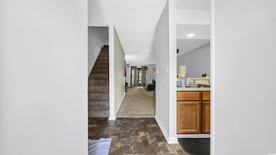 Entryway featuring baseboards, stairs, and dark stone finish floors