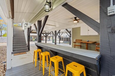 Wooden deck featuring ceiling fan, outdoor dry bar