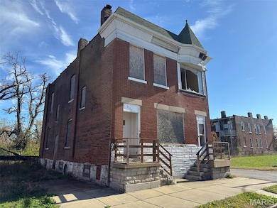 View of front facade featuring brick siding and a chimney