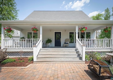 Property entrance featuring a porch and roof with shingles
