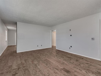 Empty room featuring baseboards, a textured ceilin