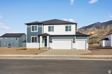 View of front of home with board and batten siding, concrete driveway, roof with shingles, an attached garage, and a mountain view