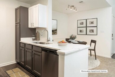 Kitchen with white cabinetry, dishwasher, light stone countertops, and a peninsula