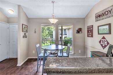 Dining area featuring dark hardwood / wood-style flooring, a textured ceiling, and a wealth of natural light