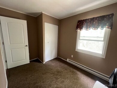 Unfurnished bedroom with crown molding, dark carpe