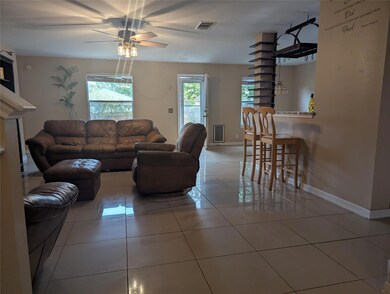 Living area with light tile patterned flooring and ceiling fan