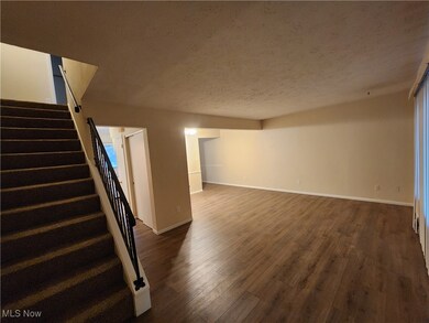 Below grade area with stairs, a textured ceiling, and dark wood-style flooring