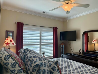Bedroom with crown molding and ceiling fan