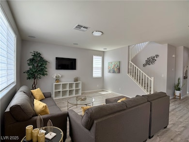 Living area with baseboards, visible vents, light