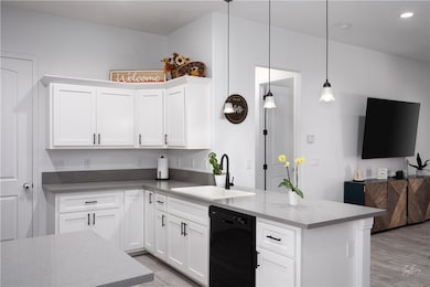 Kitchen featuring white cabinetry, dishwasher, light wood-style floors, open floor plan, and recessed lighting