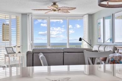 Living room with ceiling fan, a water view, and a 