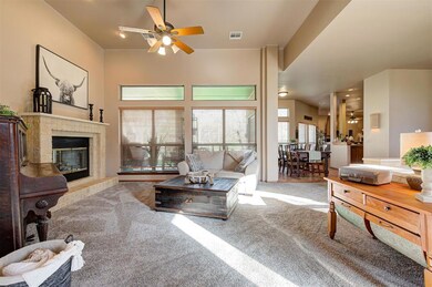 Living room with light carpet, ceiling fan, and a 