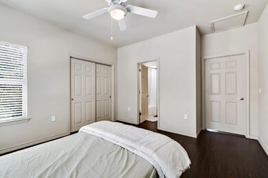 Bedroom with dark wood-type flooring, a closet, c
