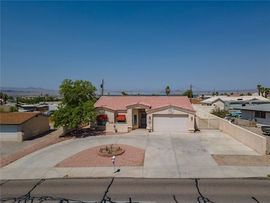 View of front of property featuring concrete driveway, a tiled roof, stucco siding, and a garage