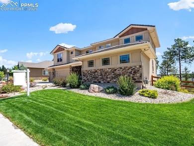 View of front of home featuring board and batten siding, a garage, and stone siding