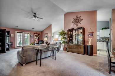 Living room featuring vaulted ceiling, light color