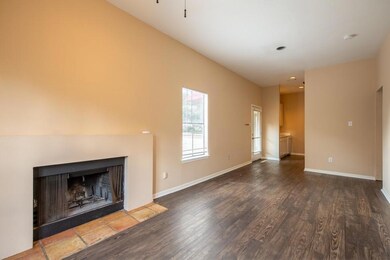 Unfurnished living room with a fireplace with flush hearth and dark wood-style flooring