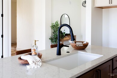 Kitchen view of a sink and light stone counters
