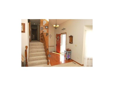 Enter into the vaulted foyer with wood floors and 