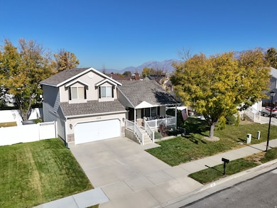 Traditional-style home featuring a porch, roof with shingles, concrete driveway, a mountain view, and an attached garage